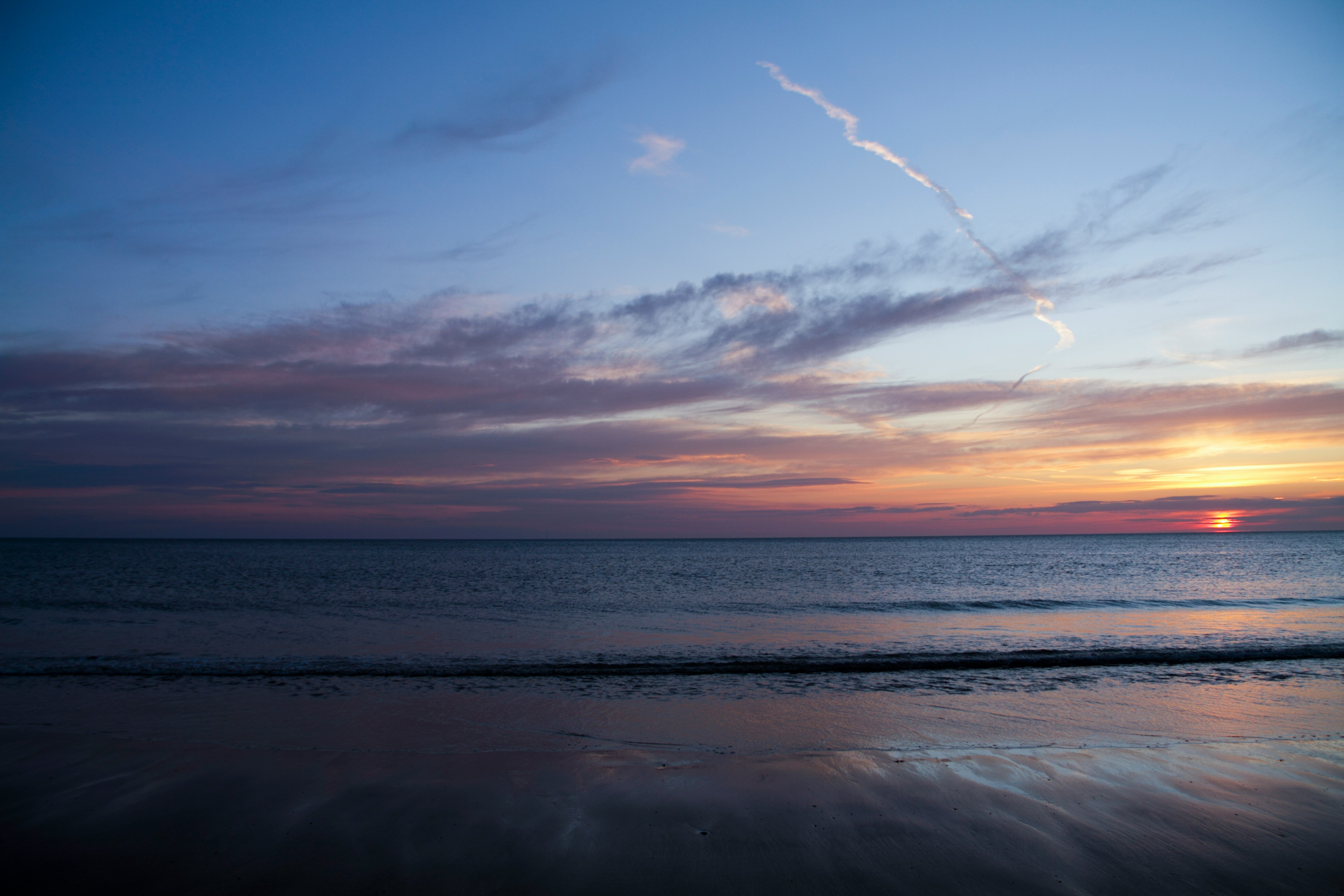 sea waves crashing on shore during sunset